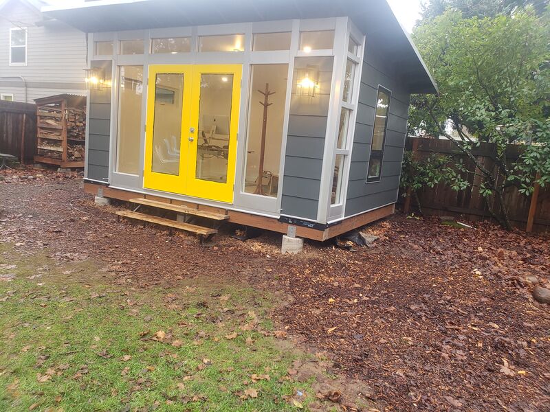Completed gray studio shed with French doors by ArchAngel Construction Services