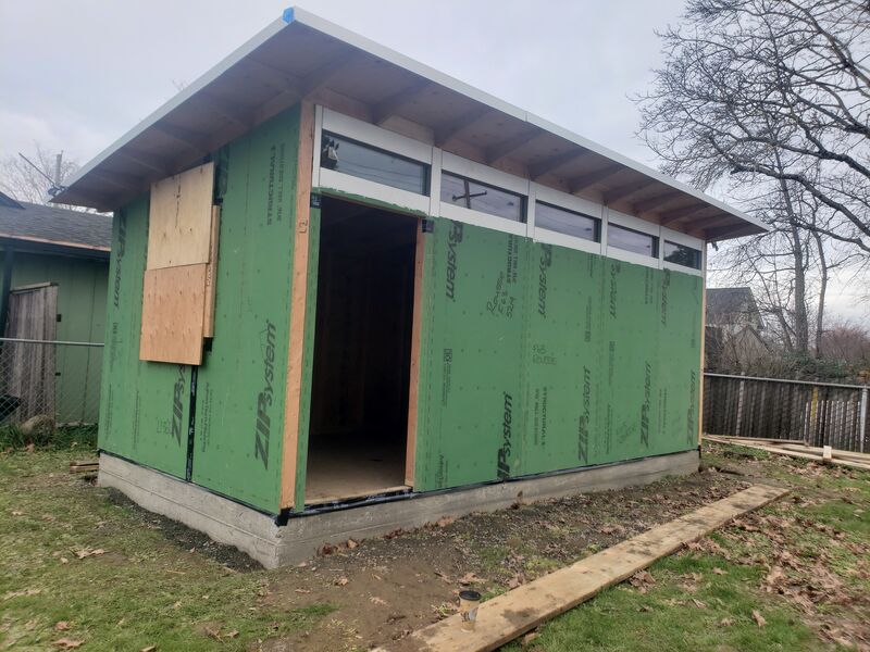 Completed slate-blue studio shed with clerestory windows by ArchAngel Construction Services