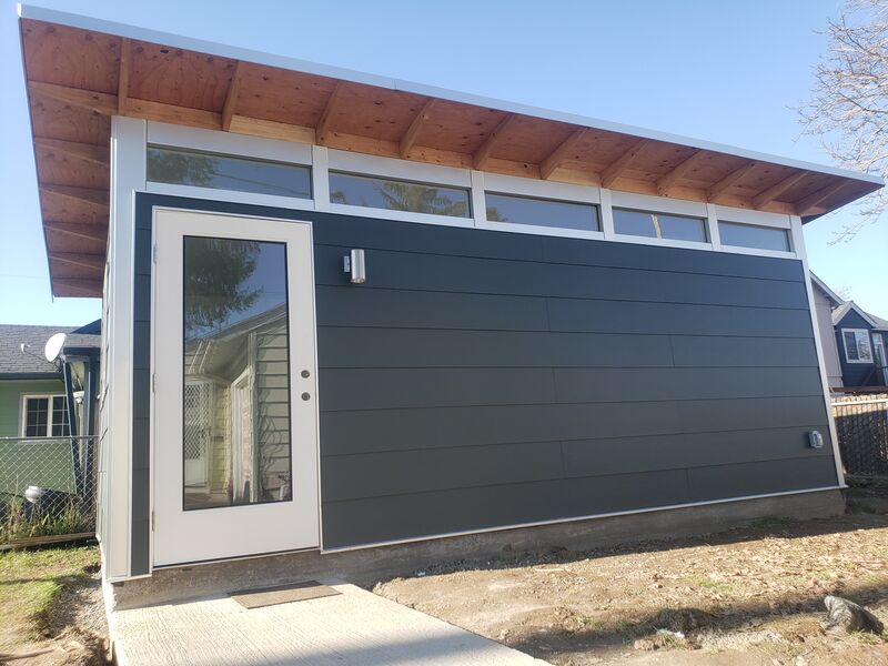 Completed studio shed with yellow entry doors, interior view by ArchAngel Construction Services