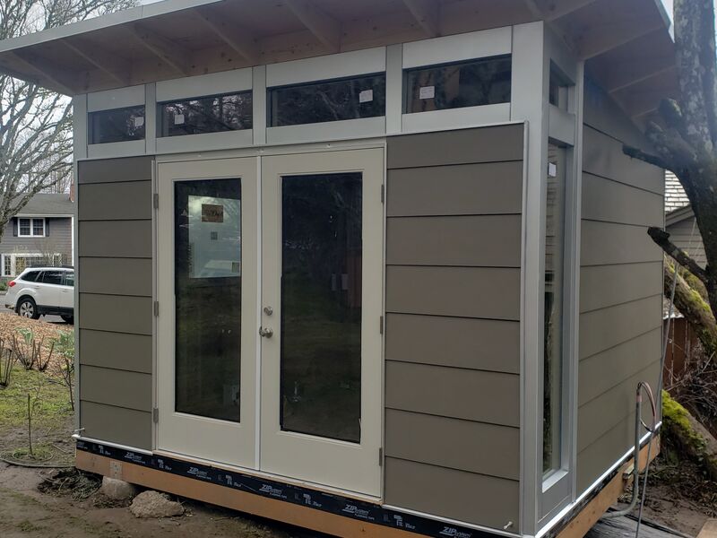 Completed dark studio shed with double glass doors by ArchAngel Construction Services
