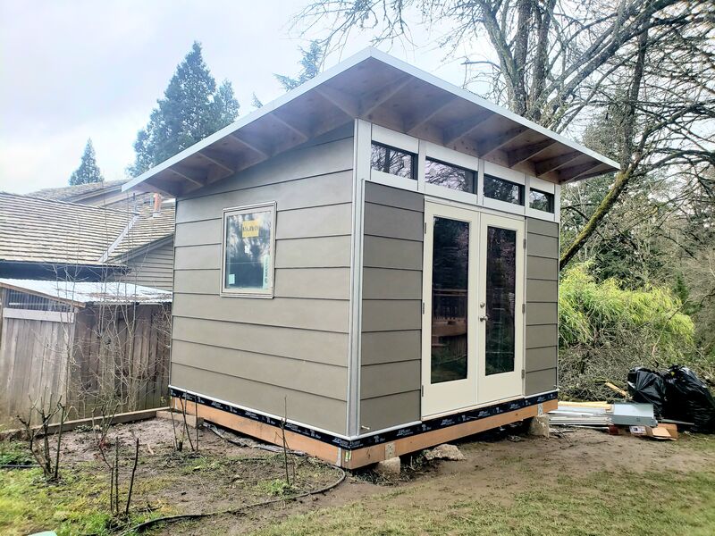 Completed dark studio shed with white French doors by ArchAngel Construction Services
