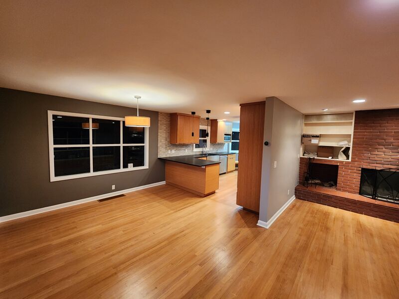Refinished hardwood floors with brick fireplace
