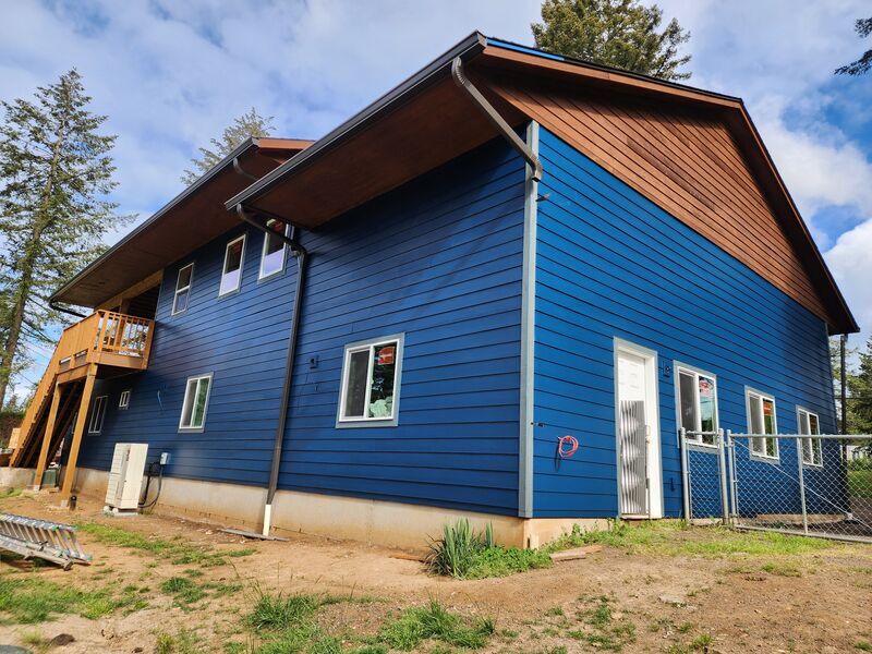 Exterior house painting with bold blue siding by ArchAngel Construction Services