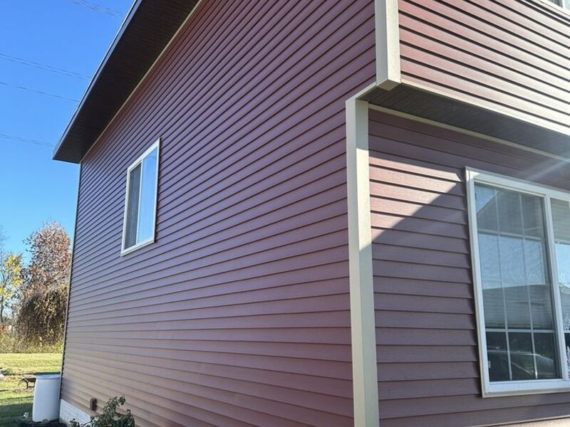 Finished home exterior with red siding, close-up corner detail