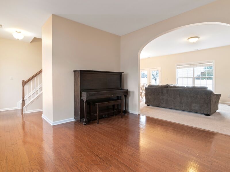 Freshly painted open living area with staircase and hardwood floors